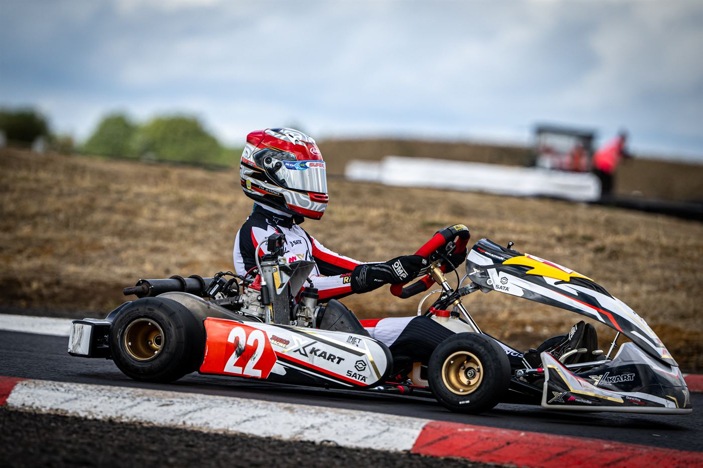 Zak Jennings in kart number 22 riding the kerb at Shenington during a Super One Junior Rotax round